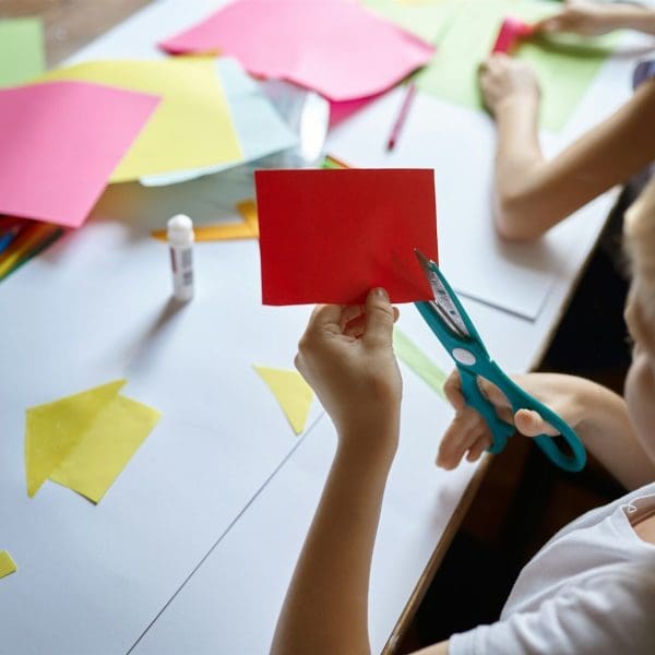 Children cut colored paper, kids in art school