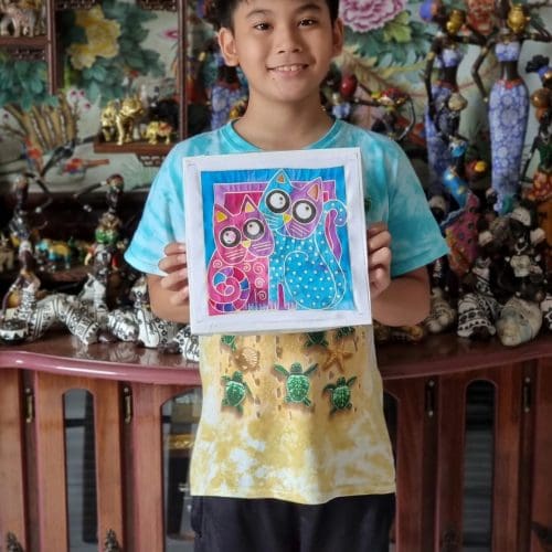 Portrait of an Asian kid holding his batik colouring art